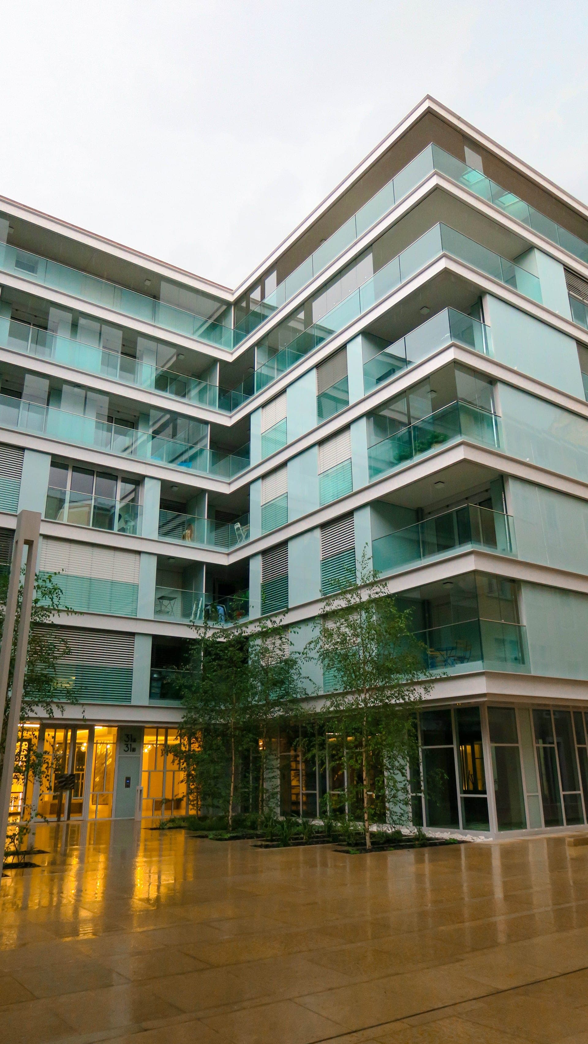Modern glass-facade residential building at dusk