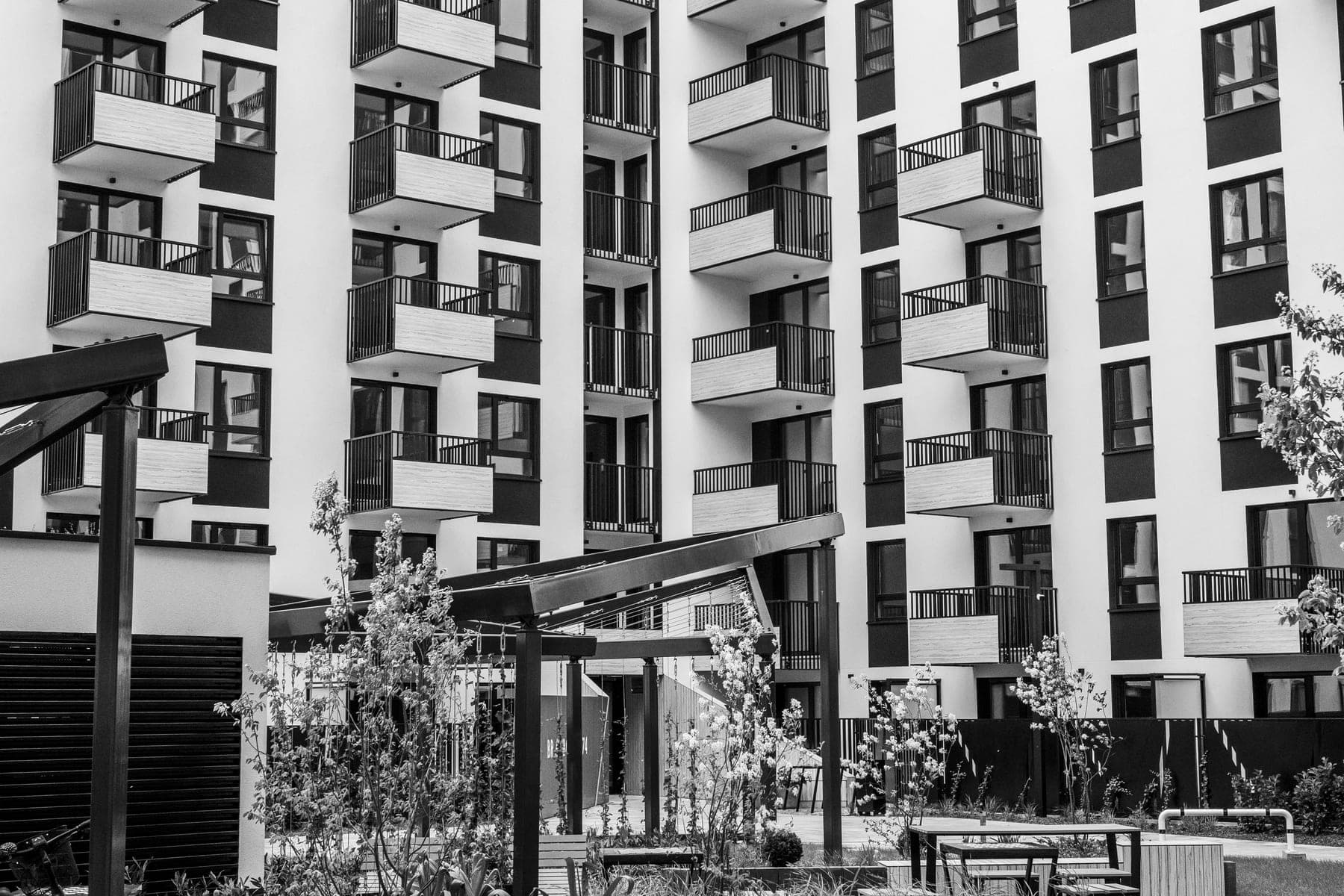 Modern residential apartment building with balconies and a landscaped courtyard